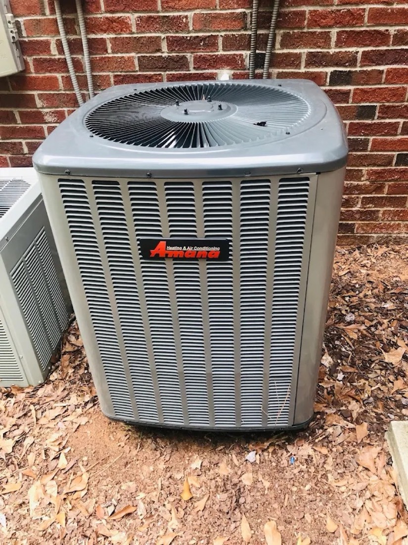 Amana outdoor AC unit installed at a brick residential home by Dynasty