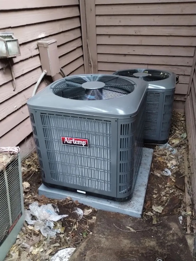 Airtemp outdoor AC system installed by Dynasty next to a residential home